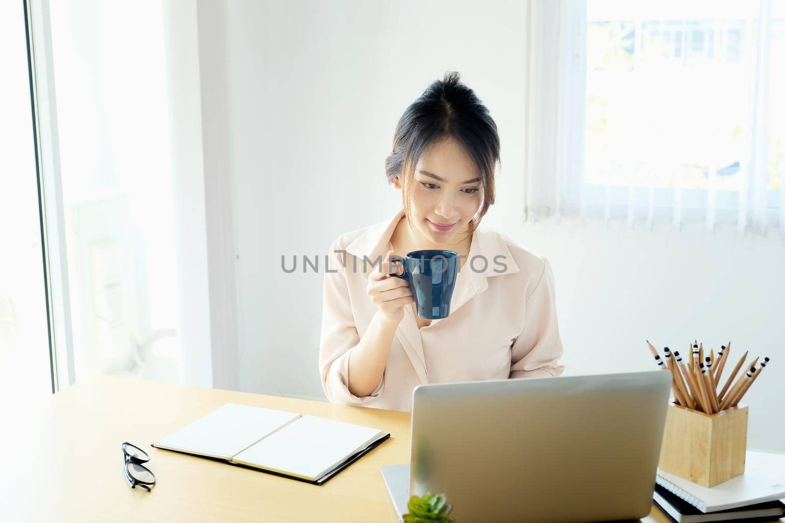 new normal, a businesswoman useing notebook and computer to work for a company Via the internet on your desk at home.