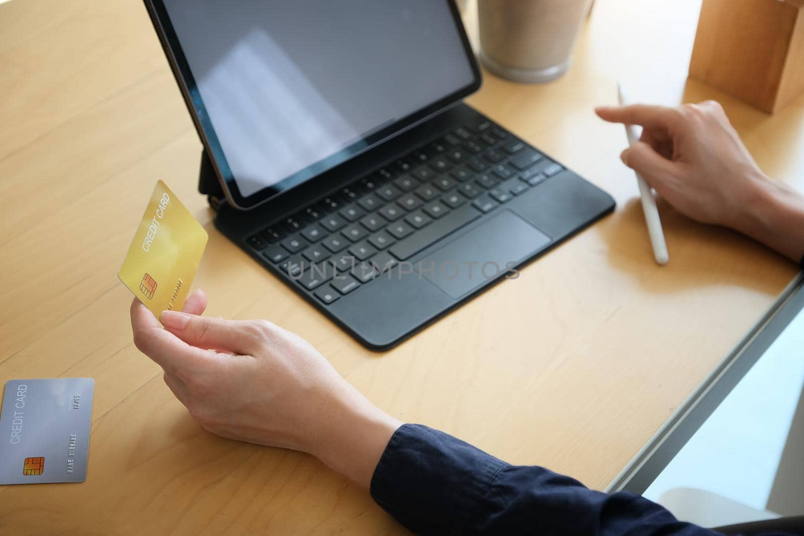 Online payment, Young Women's hands holding credit card and using tablet for online shopping.