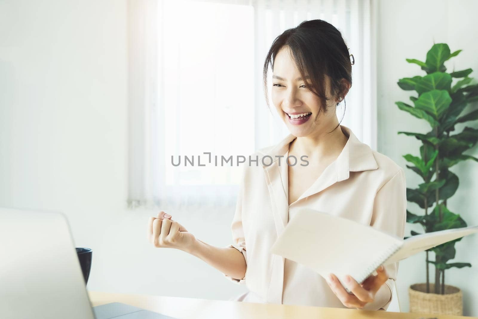 new normal, a businesswoman using computer to work for a company Via the internet on your desk at home. by Manastrong