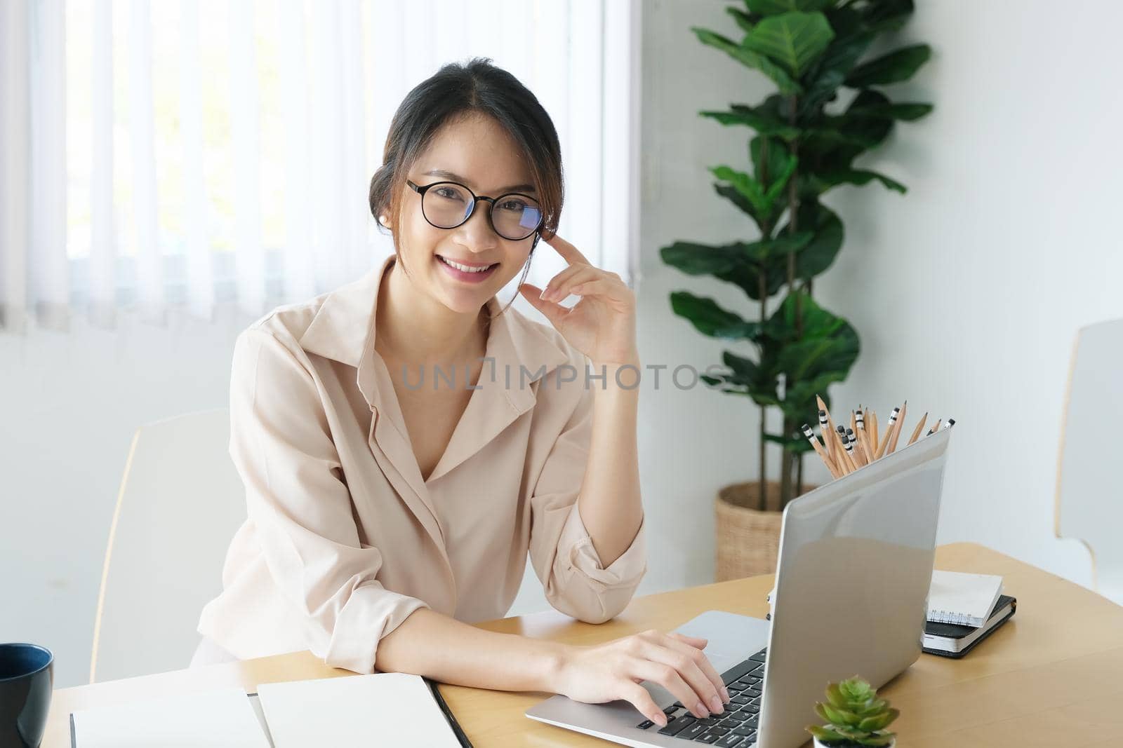 new normal, a businesswoman useing computer to work for a company Via the internet on your desk at home by Manastrong