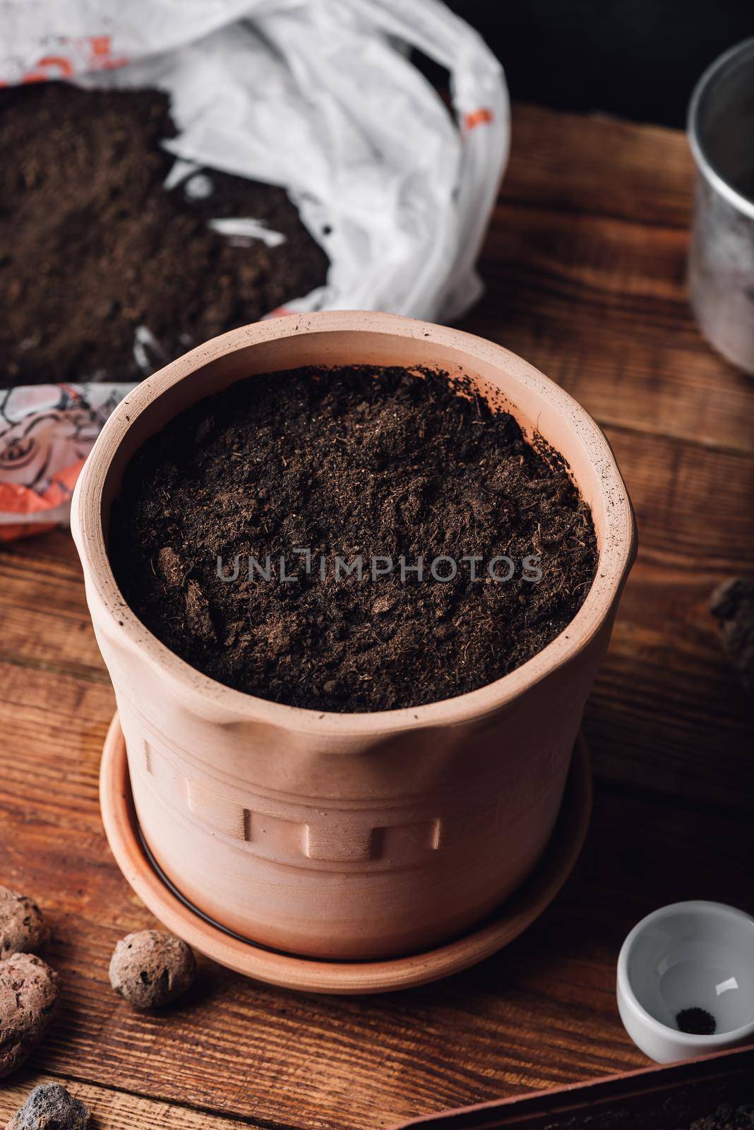 Clay Pot Filled with Potting Soil and Sowed Thyme Seeds on Wooden Table