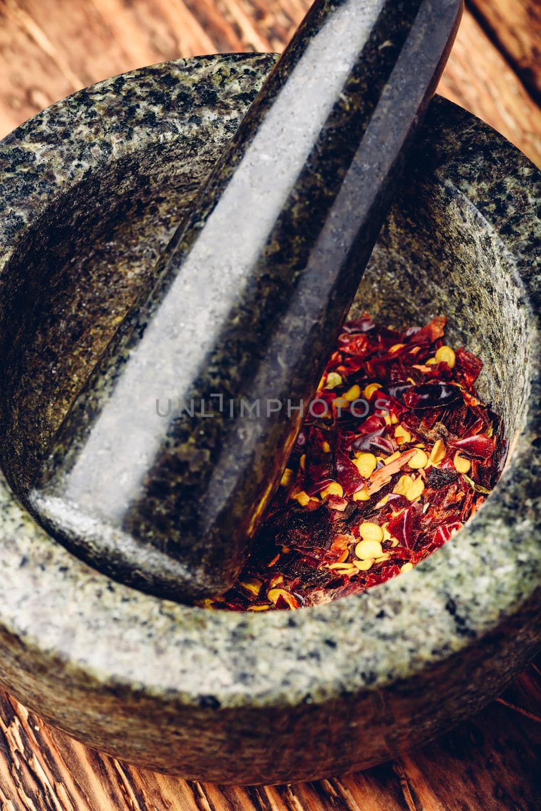 Red chili pepper grinded in mortar. High angle view