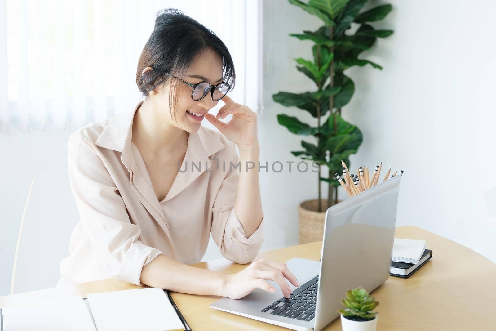 new normal, a businesswoman useing computer to work for a company Via the internet on your desk at home by Manastrong