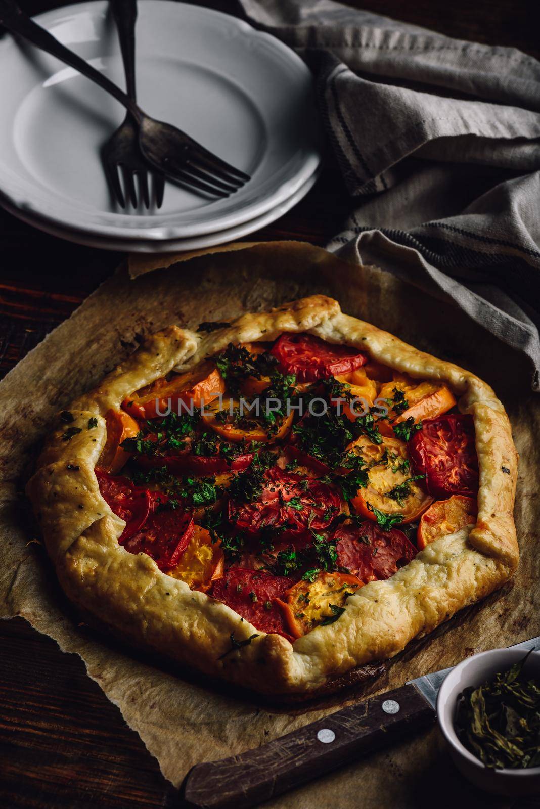 Baked tomato galette on baking paper by Seva_blsv