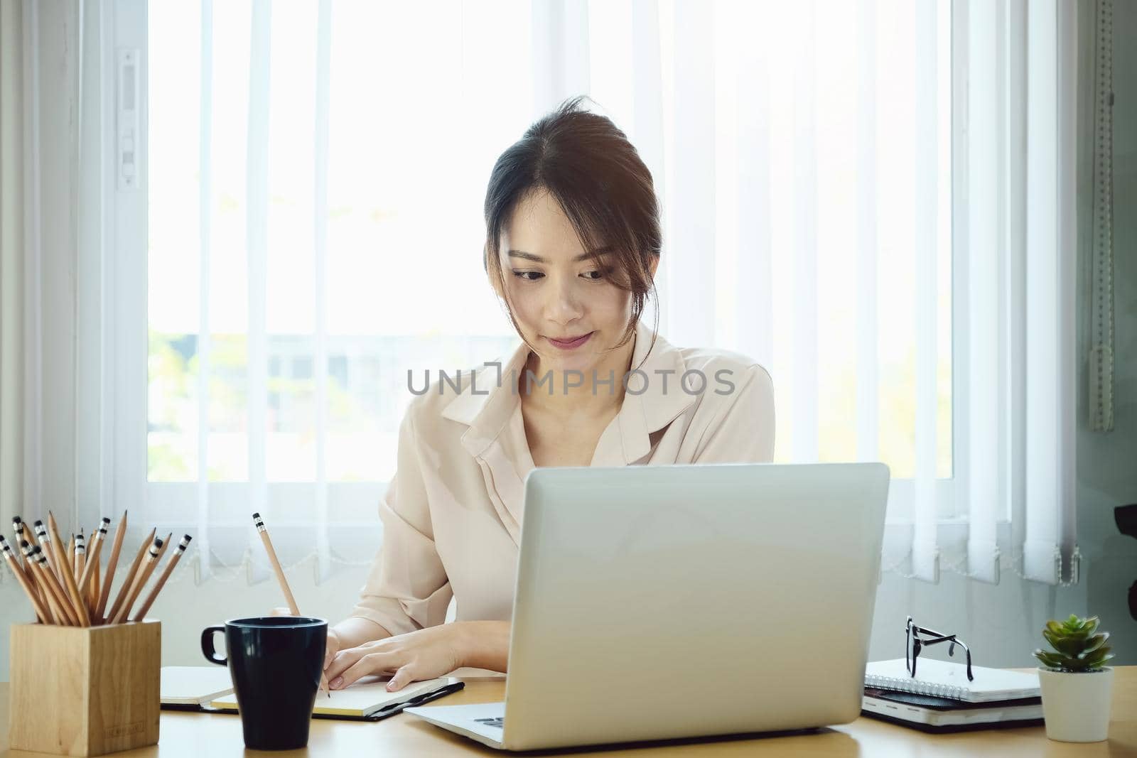 new normal, a businesswoman uses a computer to work for a company Via the internet on your desk at home.