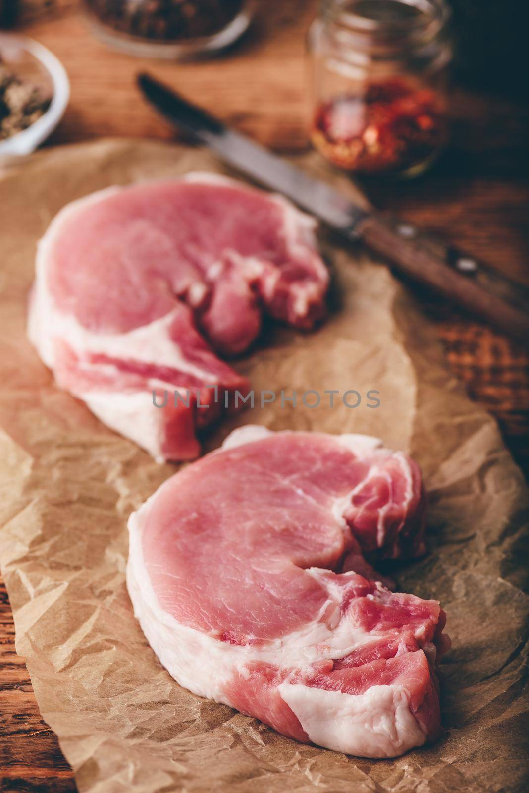 Two pork loin steaks on baking paper