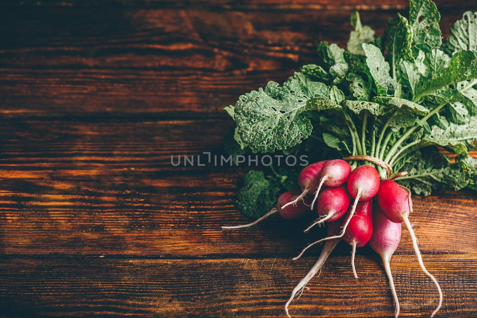 Bunch of fresh red radish on wooden table