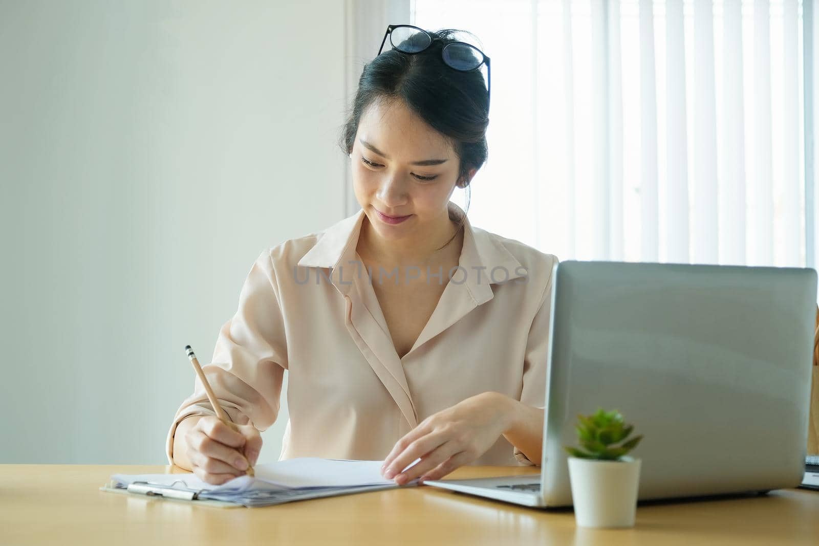 new normal, a businesswoman using notebook and computer to work for a company Via the internet on your desk at home by Manastrong