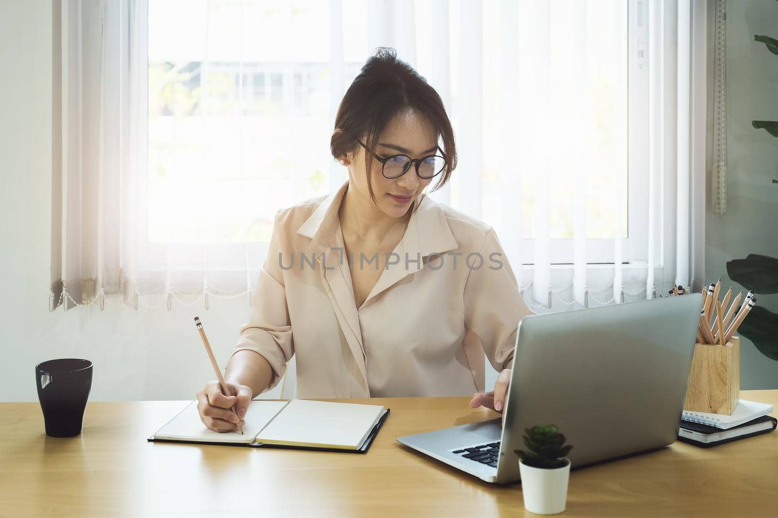 new normal, a businesswoman uses a computer to work for a company Via the internet on your desk at home by Manastrong