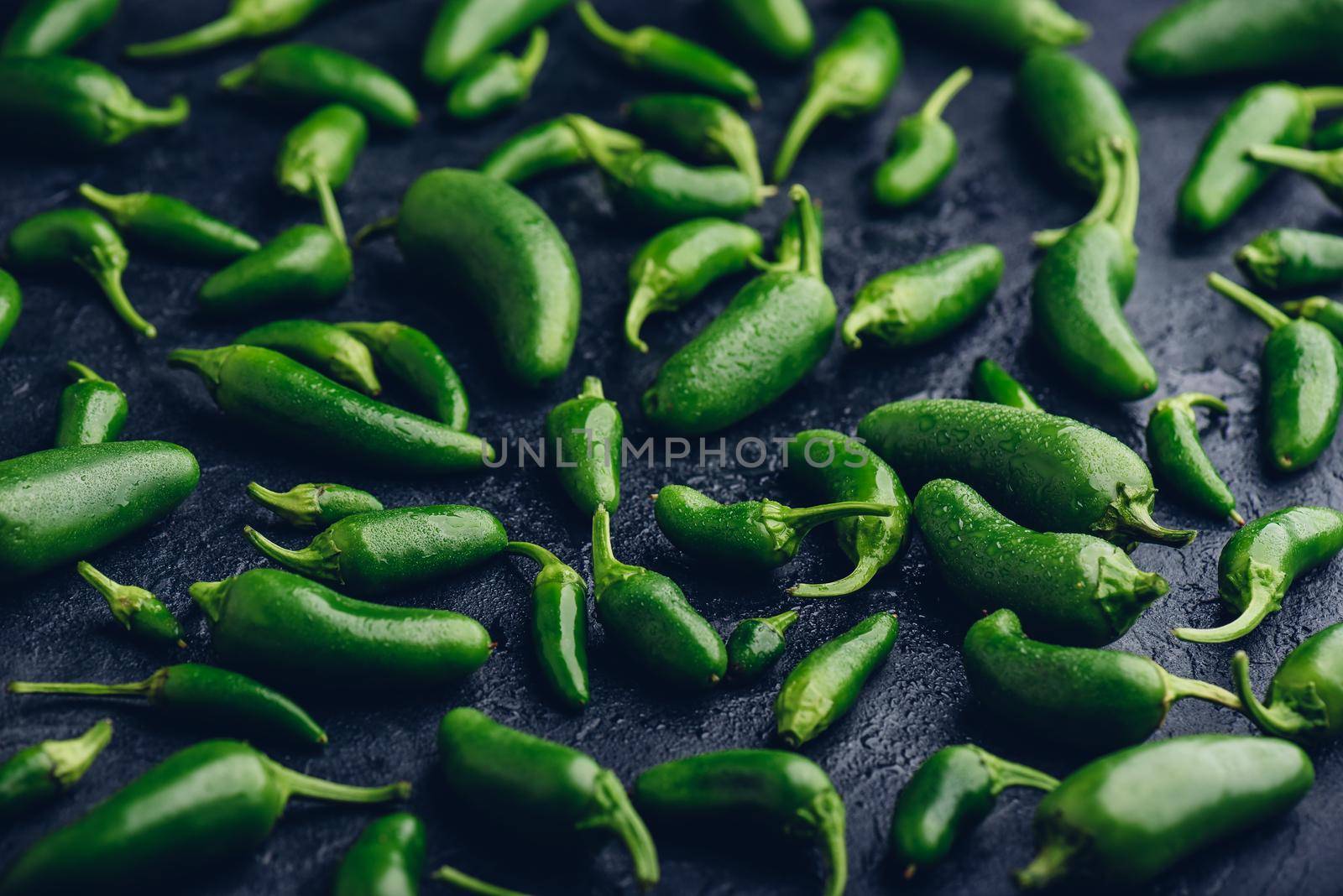 Green Jalapeno Peppers on Concrete Background by Seva_blsv