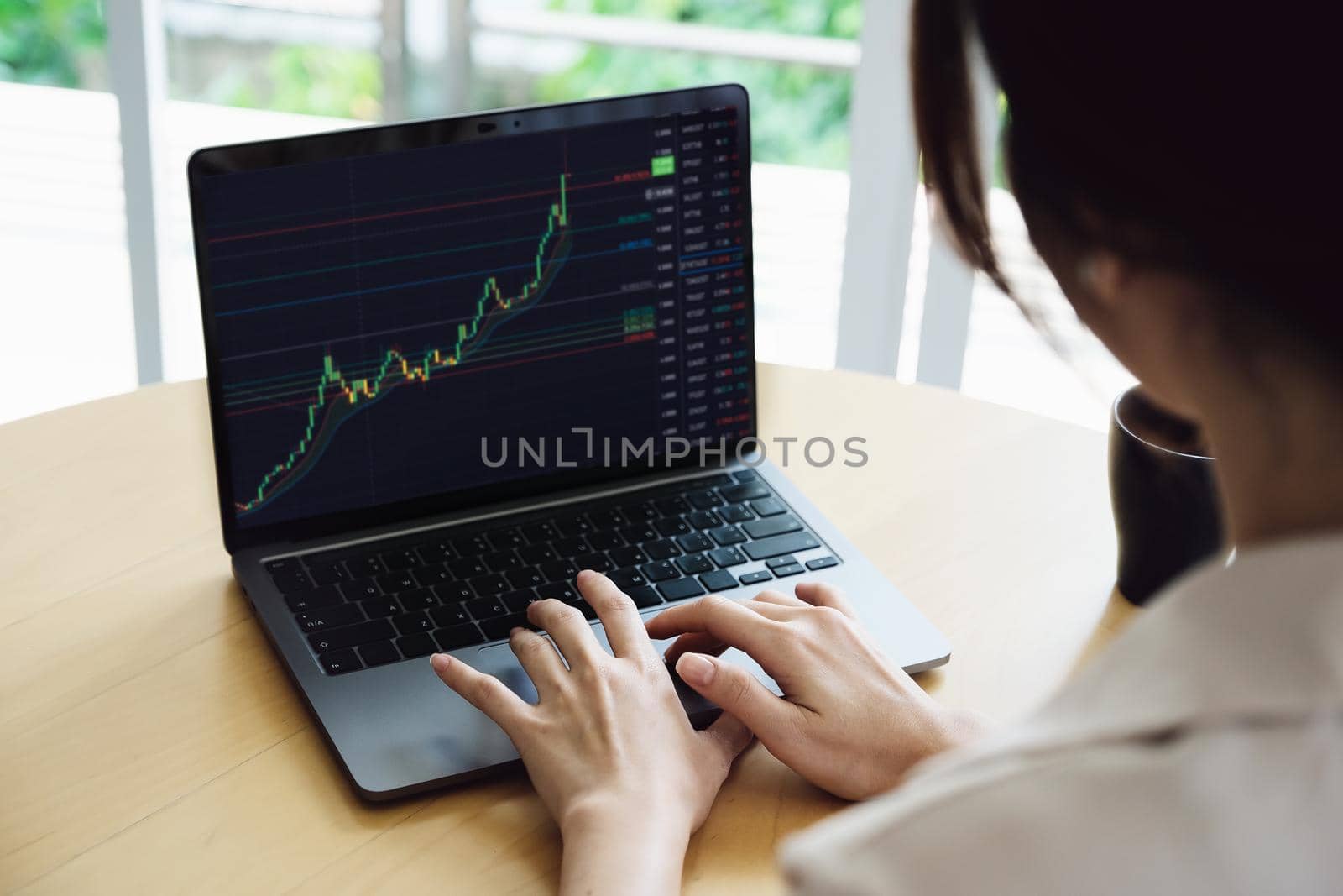 New normal, self-employed women are using a computer laptop to trade stocks for profit, buying and selling.