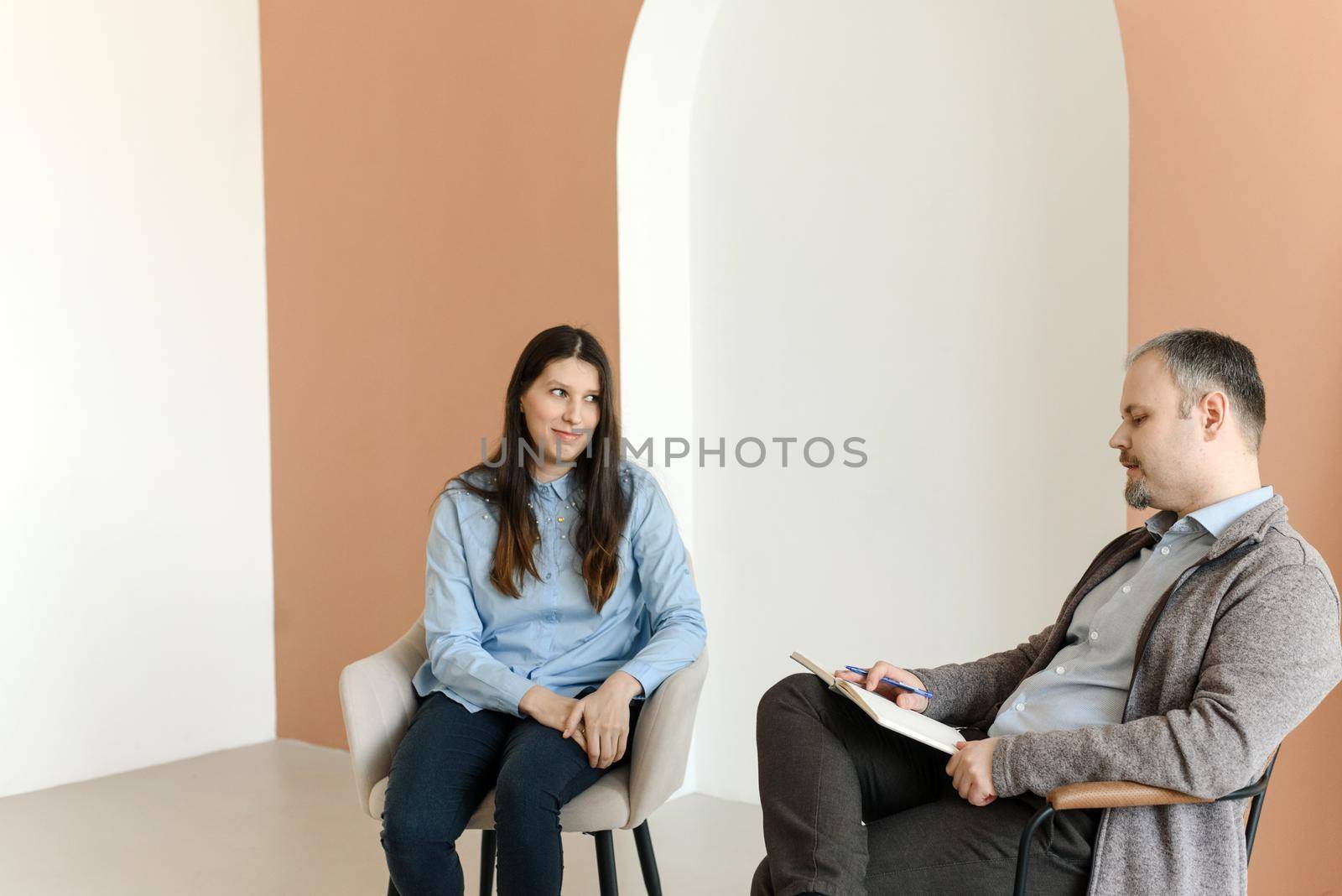 Smiling woman talking to male psychologist, feeling positive, happy that her problems are solved
