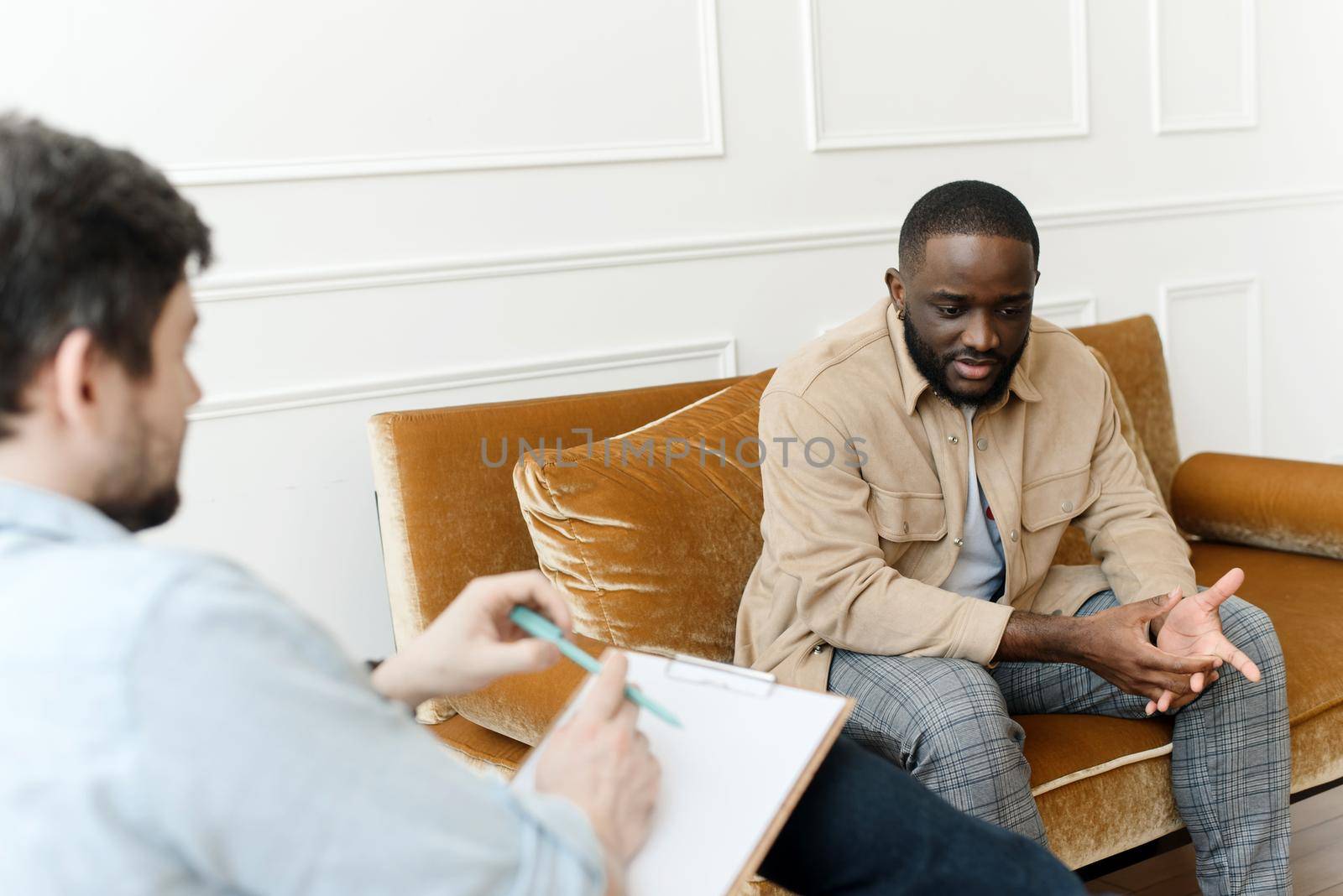 An African-American man talks to a psychologist about his problems. Psychological help service