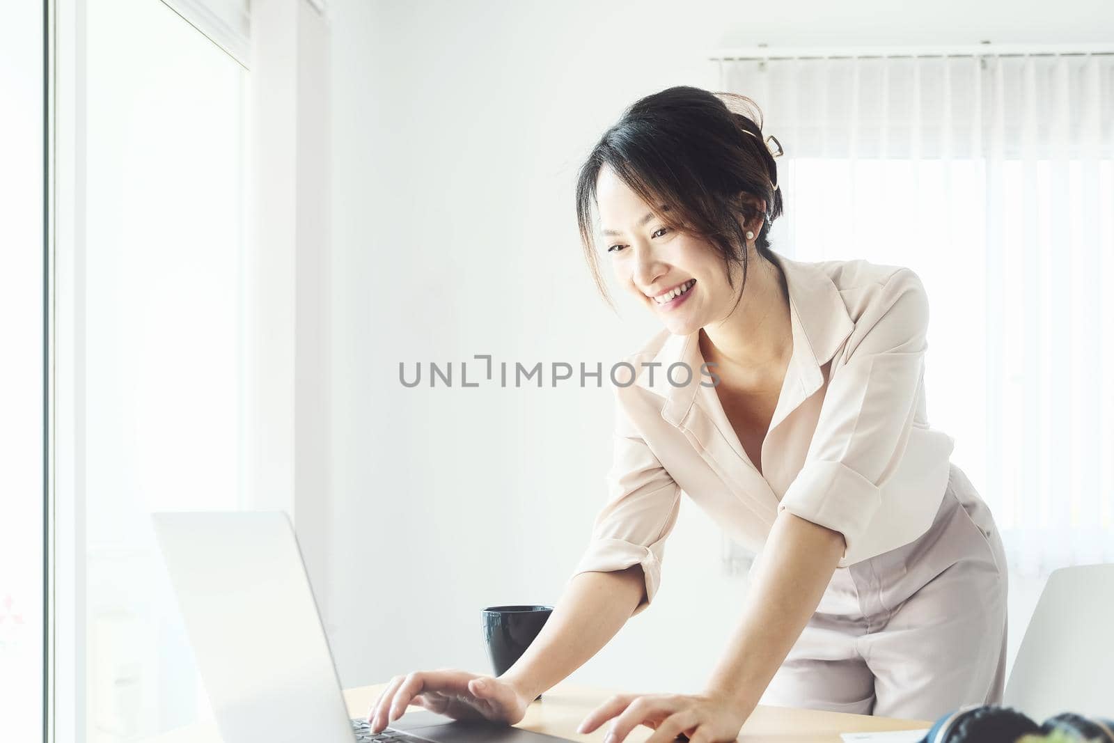 new normal, a businesswoman using computer to work for a company Via the internet on your desk at home. by Manastrong