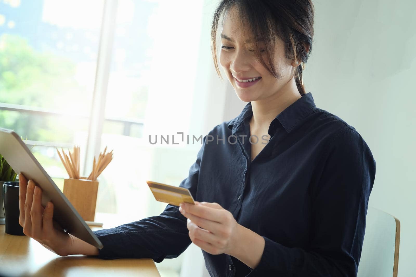 Online payment, Young Women's hands holding tablet and credit card for online shopping. by Manastrong