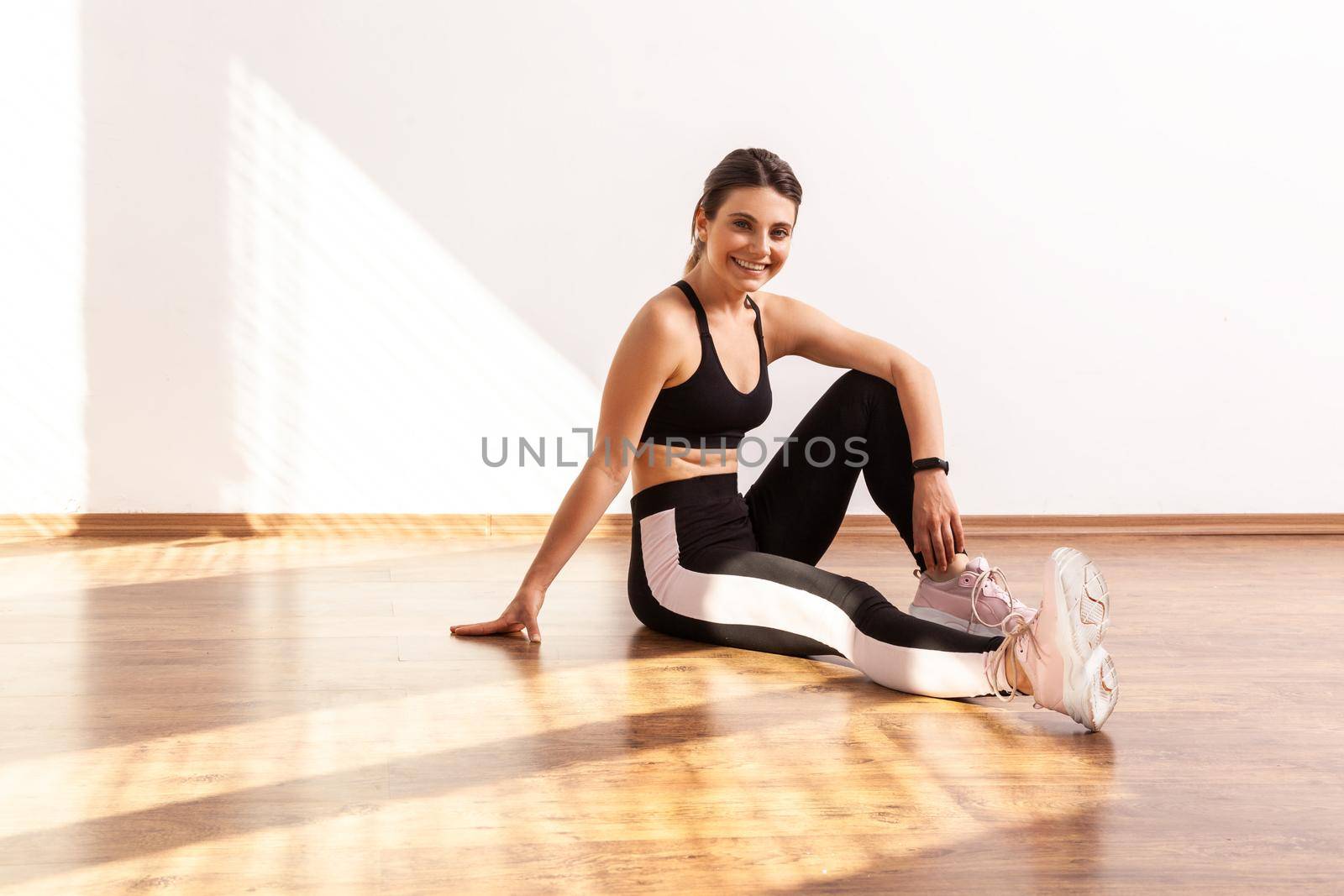 Woman sitting on floor, taking break relaxing after workout, feeling fit attractive after trainings. by Khosro1