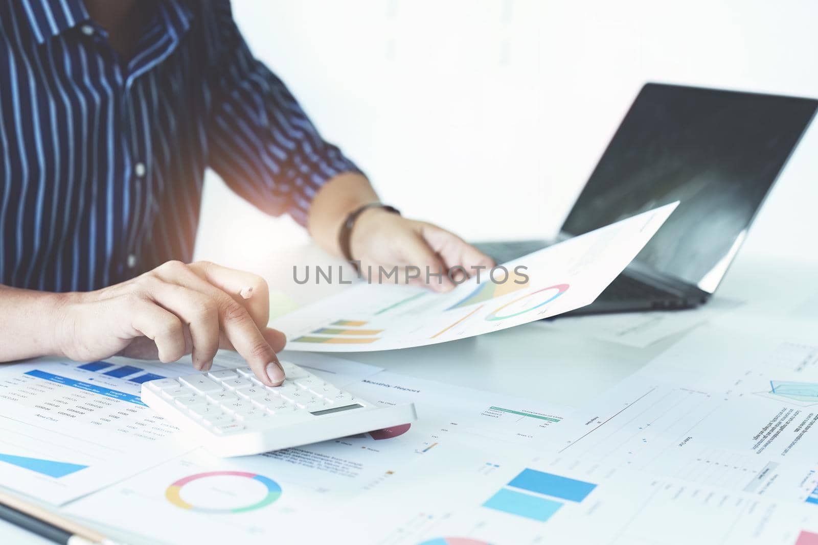 businessman hands using a calculator to check company finances and earnings and budget. calculating monthly expenses, managing budget, papers, loan documents, invoices concepts.