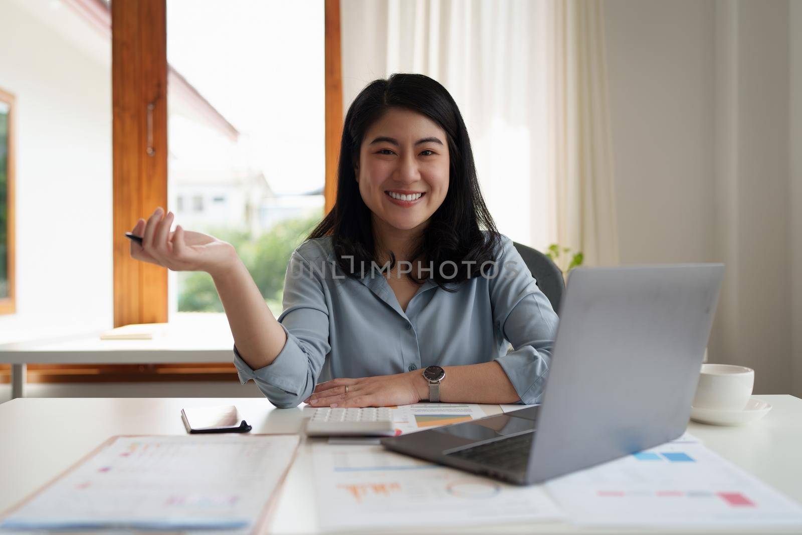 Young business person smiling while analyzing finance budget at corporate. Account and audit concept