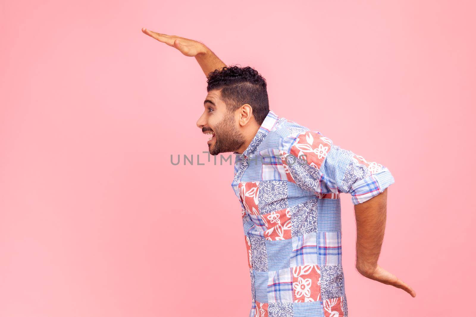 Side view of cheerful bearded man in blue casual shirt dancing, having fun and doing funny egyptian arm dance move, celebrating, rejoicing. by Khosro1