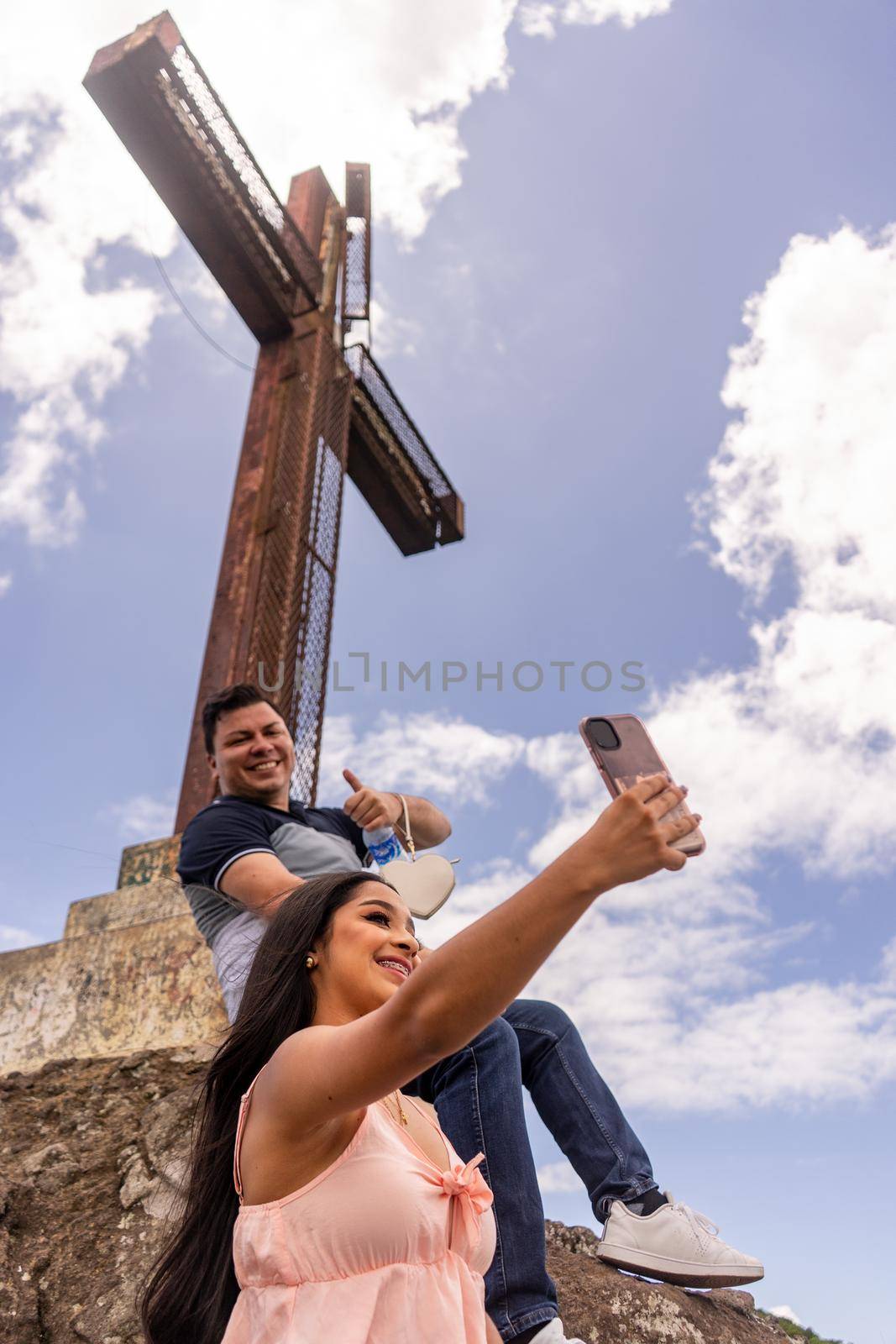 Latino man and woman taking a selfie at the pena de la cruz viewpoint by cfalvarez