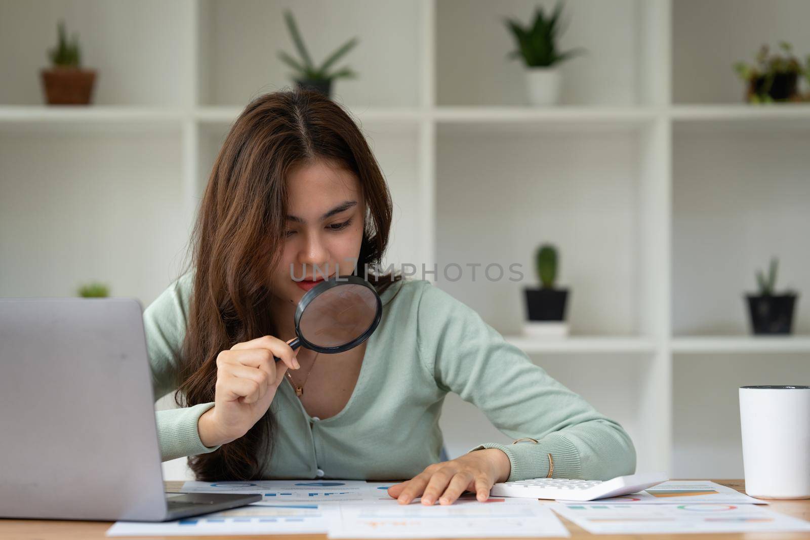 Portrait of Business woman using magnify to audit the company's financial results and budget. Account Audit Concept