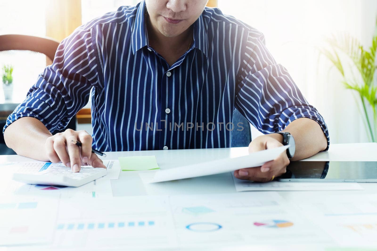 businessman hands using a calculator to check company finances and earnings and budget. calculating monthly expenses, managing budget, papers, loan documents, invoices concepts.