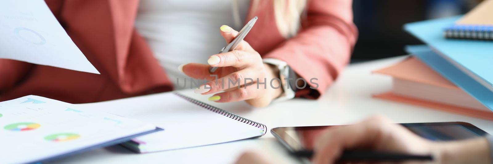 Close-up of coworkers discussing working moments and checking financial report. Business papers with graphs on desk. Business, economy, investment concept