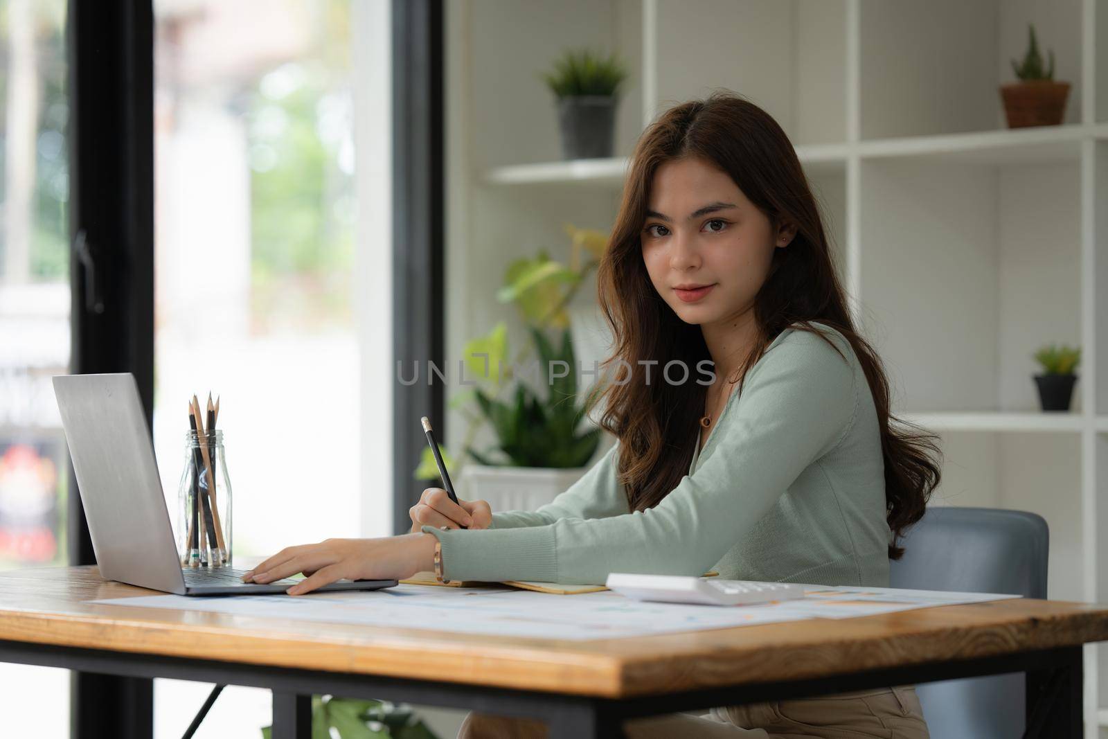 Portrait of Business woman using laptop to calculate the company's financial results and budget. Account Audit Concept