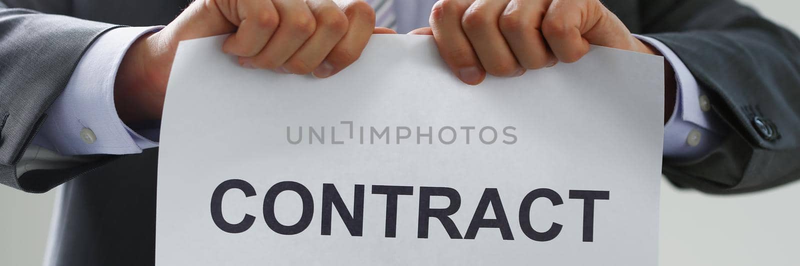 Close-up of male worker in costume and tie tear contract paper apart, end of business offer. Get jobless, job loss, staff reduction, end of career concept