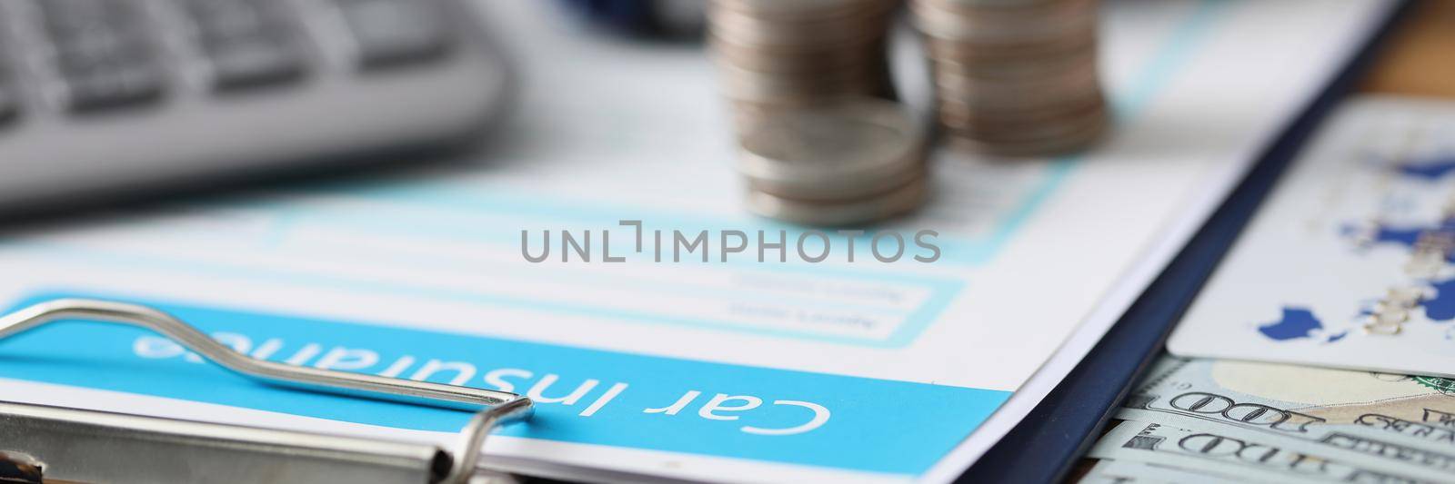 Close-up of car insurance paper, calculator and stack of coins on workplace. Prevent traffic accident and sign contract. Vehicle insurance, safety concept