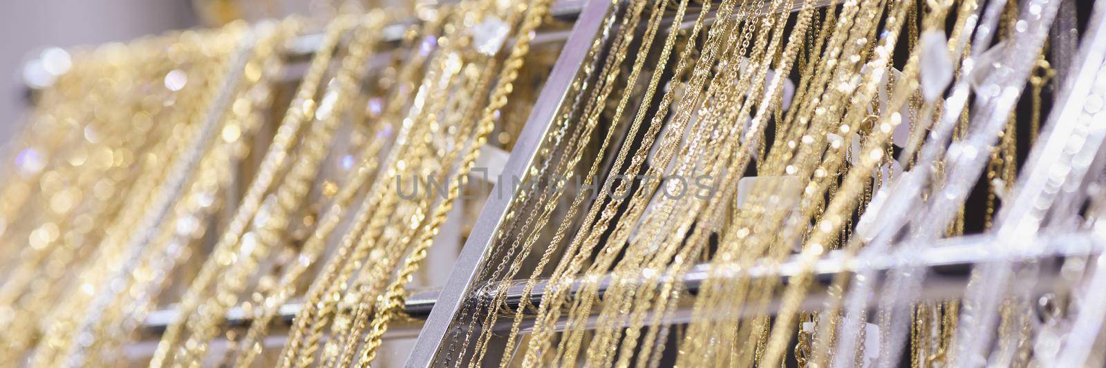 Close-up of elegant gold and silver chain necklaces for sale in jewelry store. Set of recommend products for costumers. Beauty, luxury, shop, sale concept