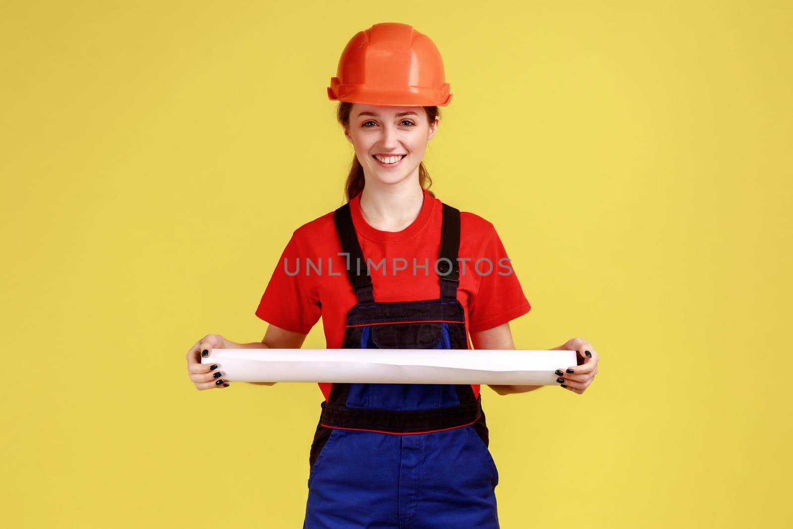 Ambitious woman architect holding rolled blueprints in hands, project of new building. by Khosro1