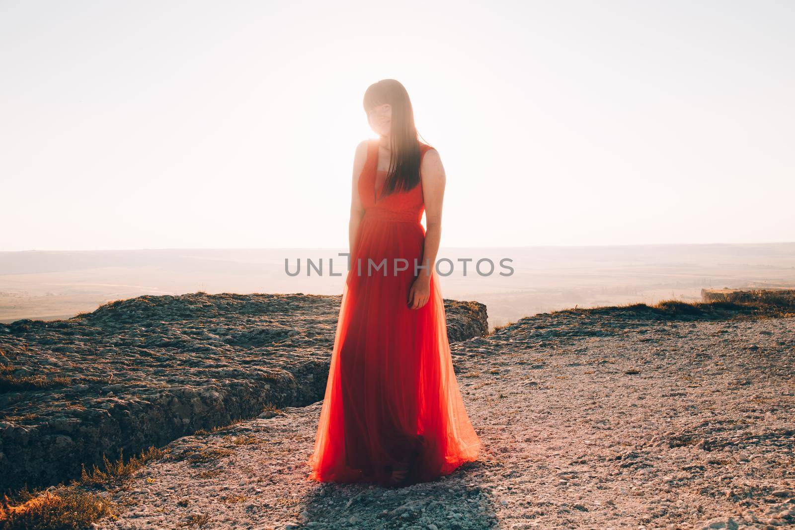 A girl in a red dress on the background of the mountains lifestyle. Illustrating articles about travel. A girl with a beautiful view. Vacation in Crimea. White rock. View of the villages. Lifestyle processing. Copy space .