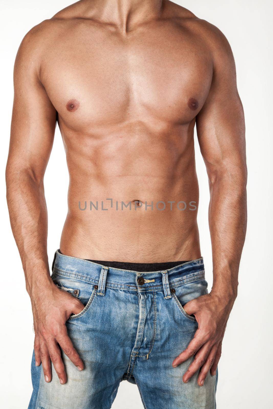 Portrait of unrecognizable attractive athletic sexy man wearing jeans, standing posing shirtless, keeping hands on pockets, beautiful male sporty body. Indoor studio shot isolated on white background.