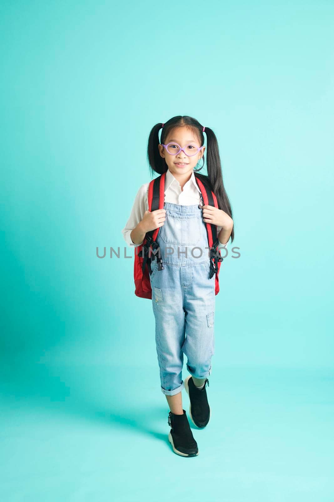 Kid students girl going to school, i like school. Smiling pose for camera on sky blue studio background. school concept.