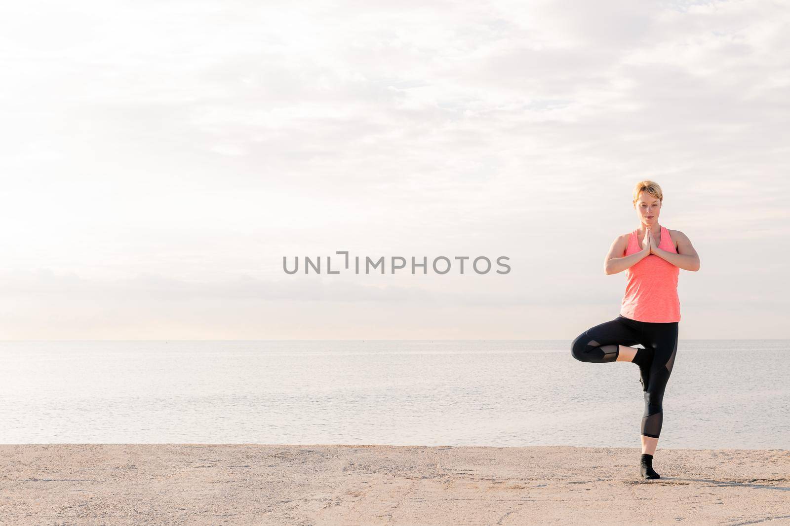 woman practicing yoga balance at sunrise by raulmelldo