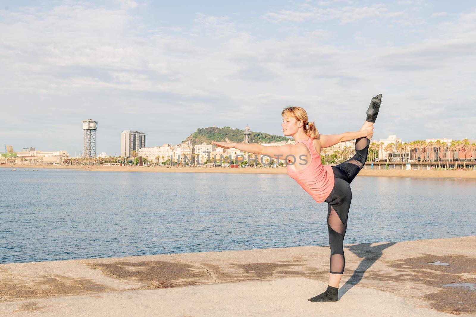 woman doing yoga stretches in front of the sea by raulmelldo