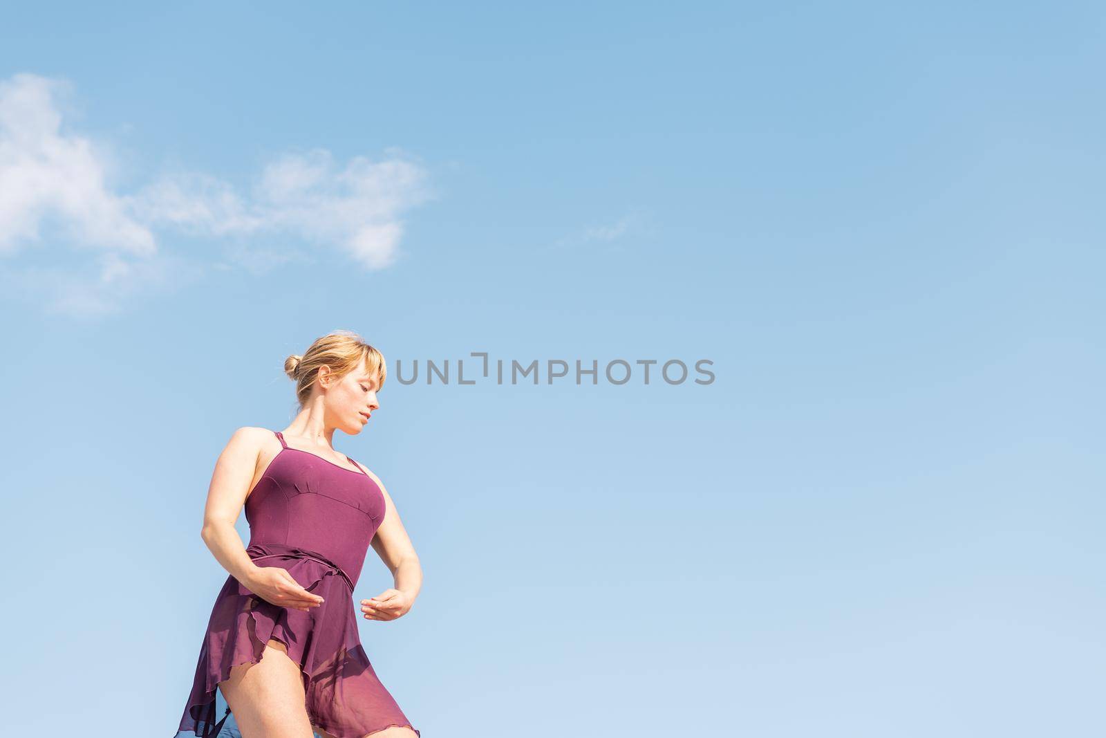 young caucasian ballet dancer posing with the sky in the background, dance and freedom concept, copy space for text