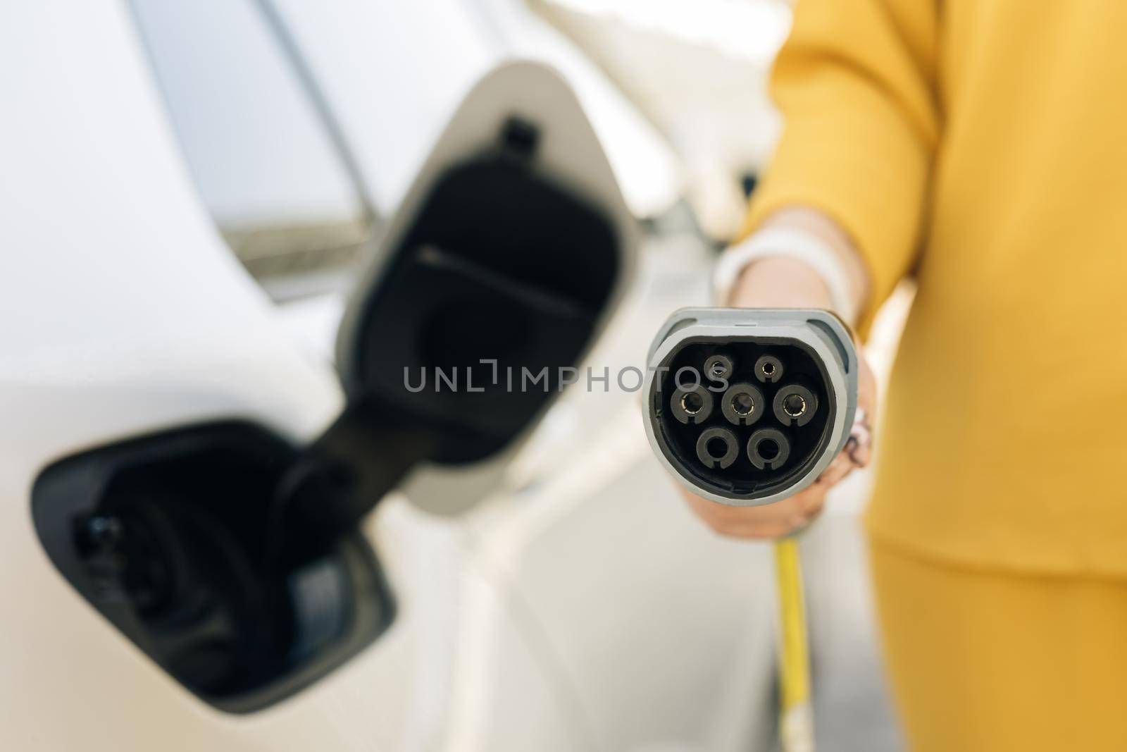 Type 2 CCS plug port cable on electric vehicle. Fast charging socket type 2 combo electric car. DC - CCS type 2 EV charging connector at EV car. Eco friendly alternative energy green environment