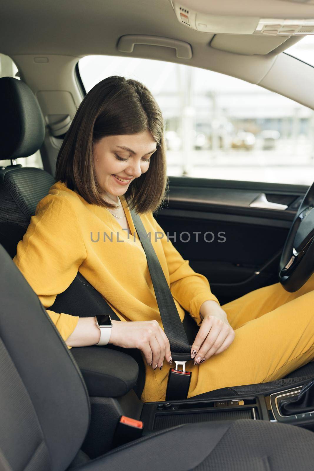 Woman fastens car seat belt with hand. Compliance with safety rules for driving. Protection of female person in vehicles. Fasten your body with a seat belt in the car. Road safety regulations concept