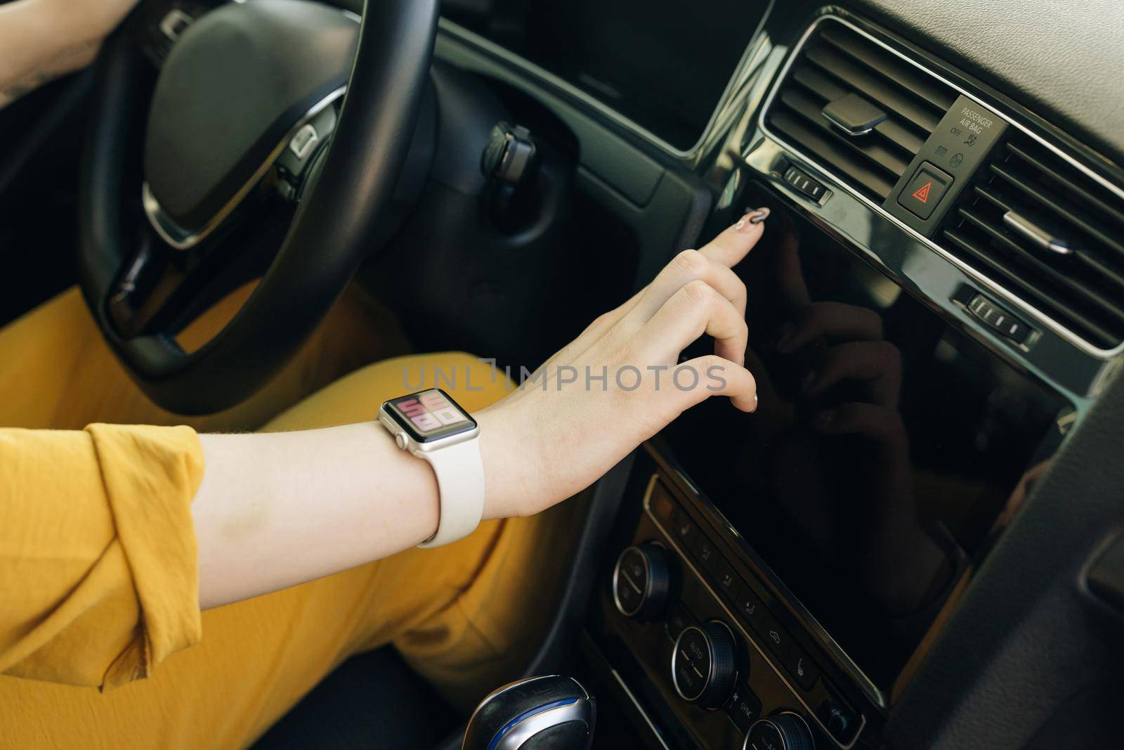 Unrecognizable female woman hand touching, clicking, tapping, sliding, dragging and swiping on screen monitor on modern luxury car. Interface concept