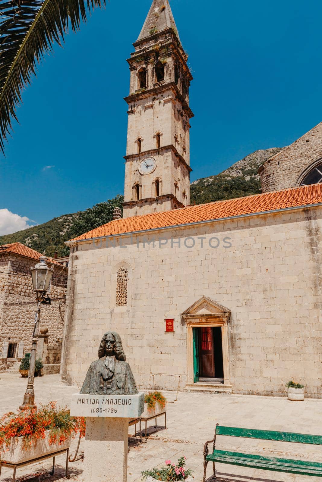 Historic city of Perast at Bay of Kotor in summer, Montenegro. Scenic panorama view of the historic town of Perast at famous Bay of Kotor with blooming flowers on a beautiful sunny day with blue sky and clouds in summer, Montenegro, southern Europe