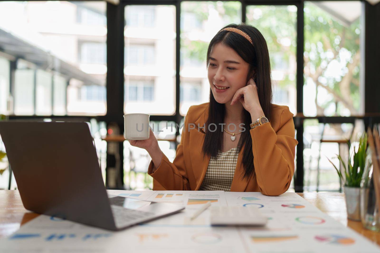 Attractive Asian business woman working with a laptop to audit financial at office. Account concept