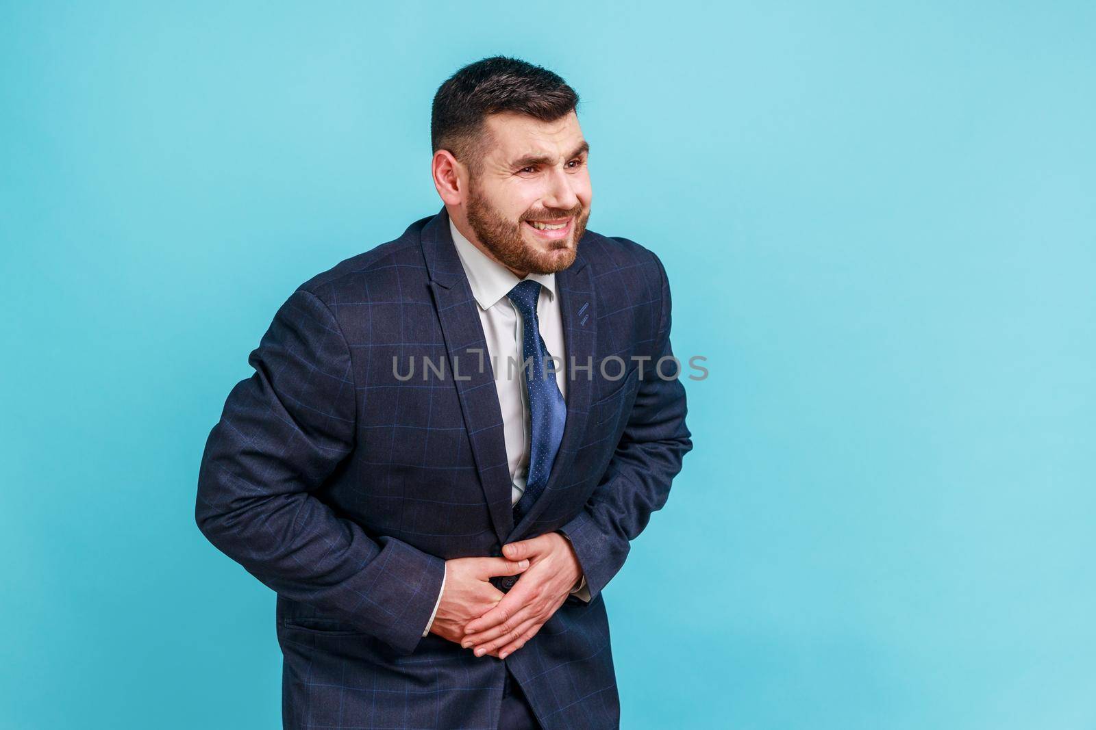 Sick bearded businessman wearing official style suit holding hands on stomach feeling acute pain, suffering indigestion and nausea, duodenal ulcer. by Khosro1