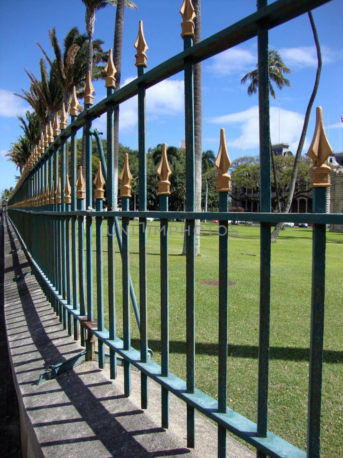 Iolani Palace Fence is a half mile ornamental fence that surrounds the palace grounds was built in 1892.  The fence is painted dark green and the spikes are gilded in gold paint.  The fence was built by Champion Iron Co. of Toledo, Ohio uses no welding held together with post and screws.