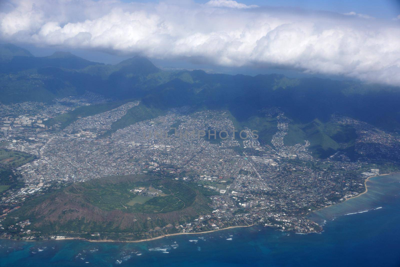 Aerial of Diamond Head Crater, Kaimuki, Kahala, and Honolulu with clouds hanging over the mountains on nice day. November 2014. 