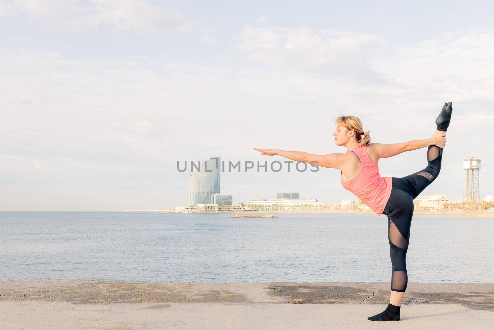 sportswoman practicing balance and yoga stretches by raulmelldo