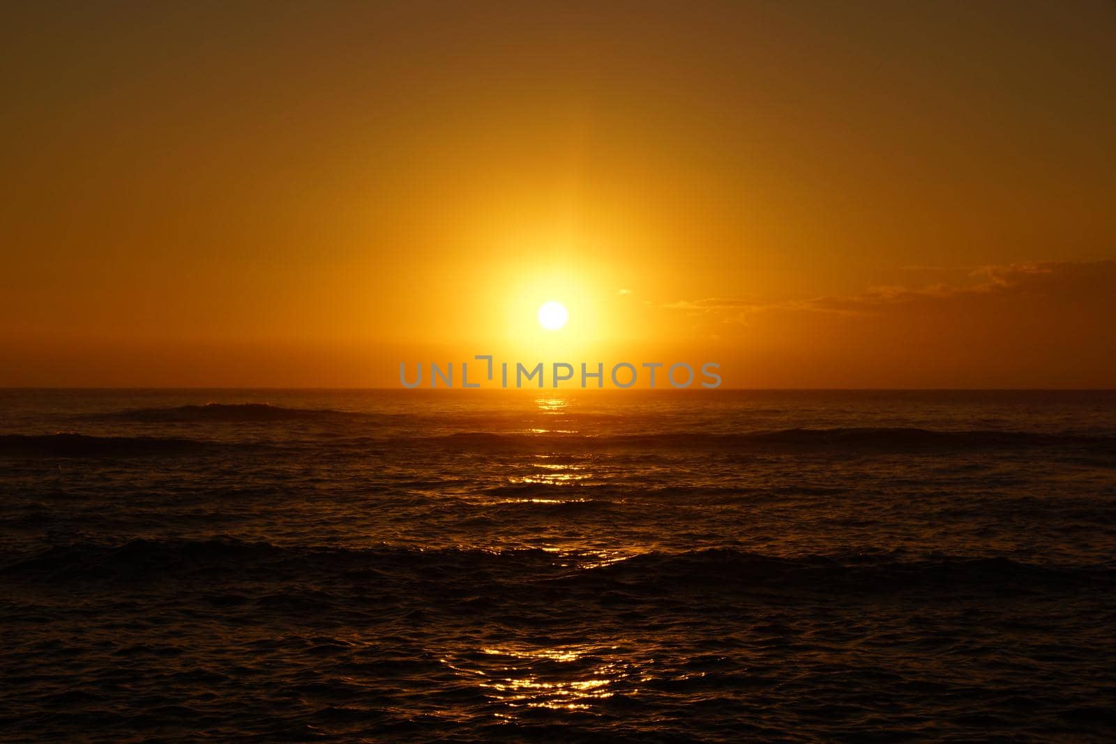 Sunrise over the ocean with waves rolling toward shore by EricGBVD