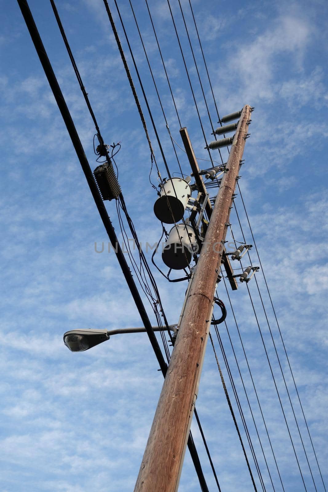 High Voltage Power Lines line wooden Utility pole with blue cloudy sky on Oahu, Hawaii.