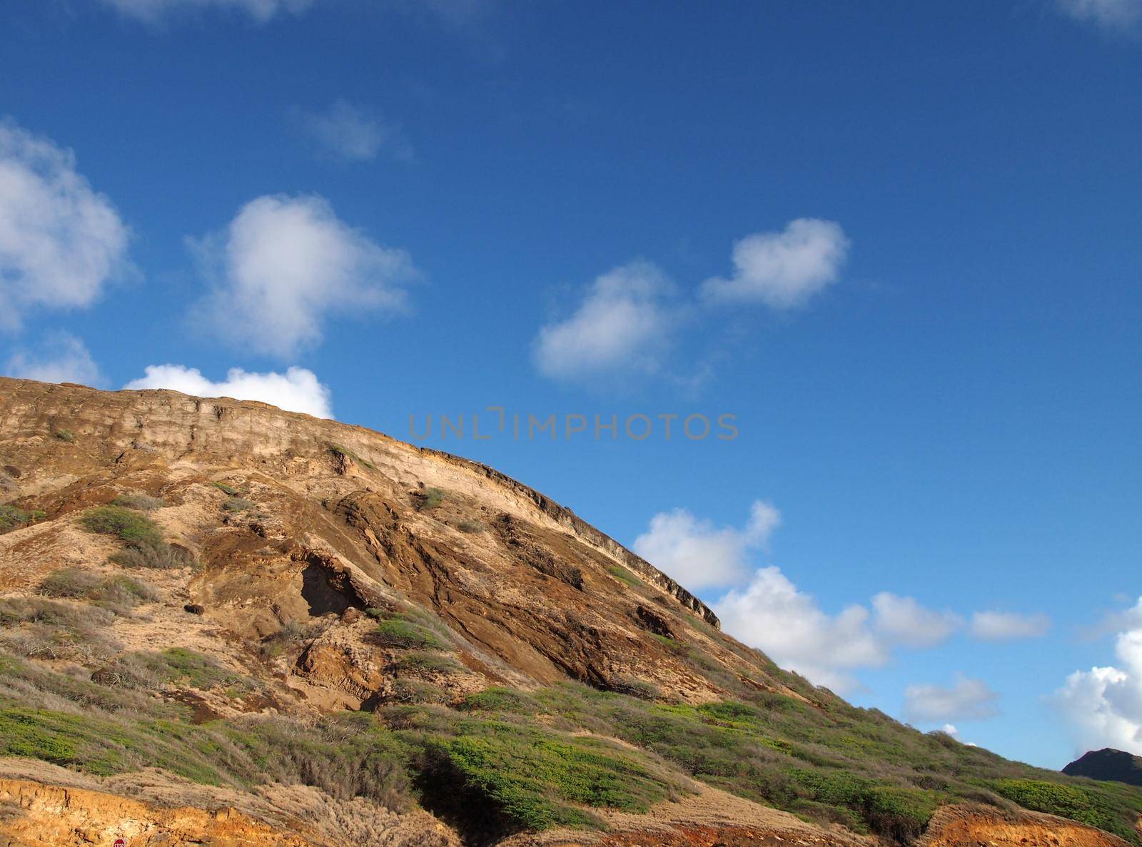 Close-up of top of Koko Head Mountain with blue sky with clouds visible on Oahu, Hawaii.  